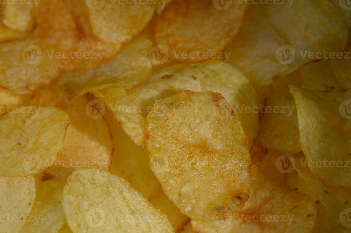 Crunchy golden potato chips scattered in a bowl create a tempting snack experience at any gathering photo