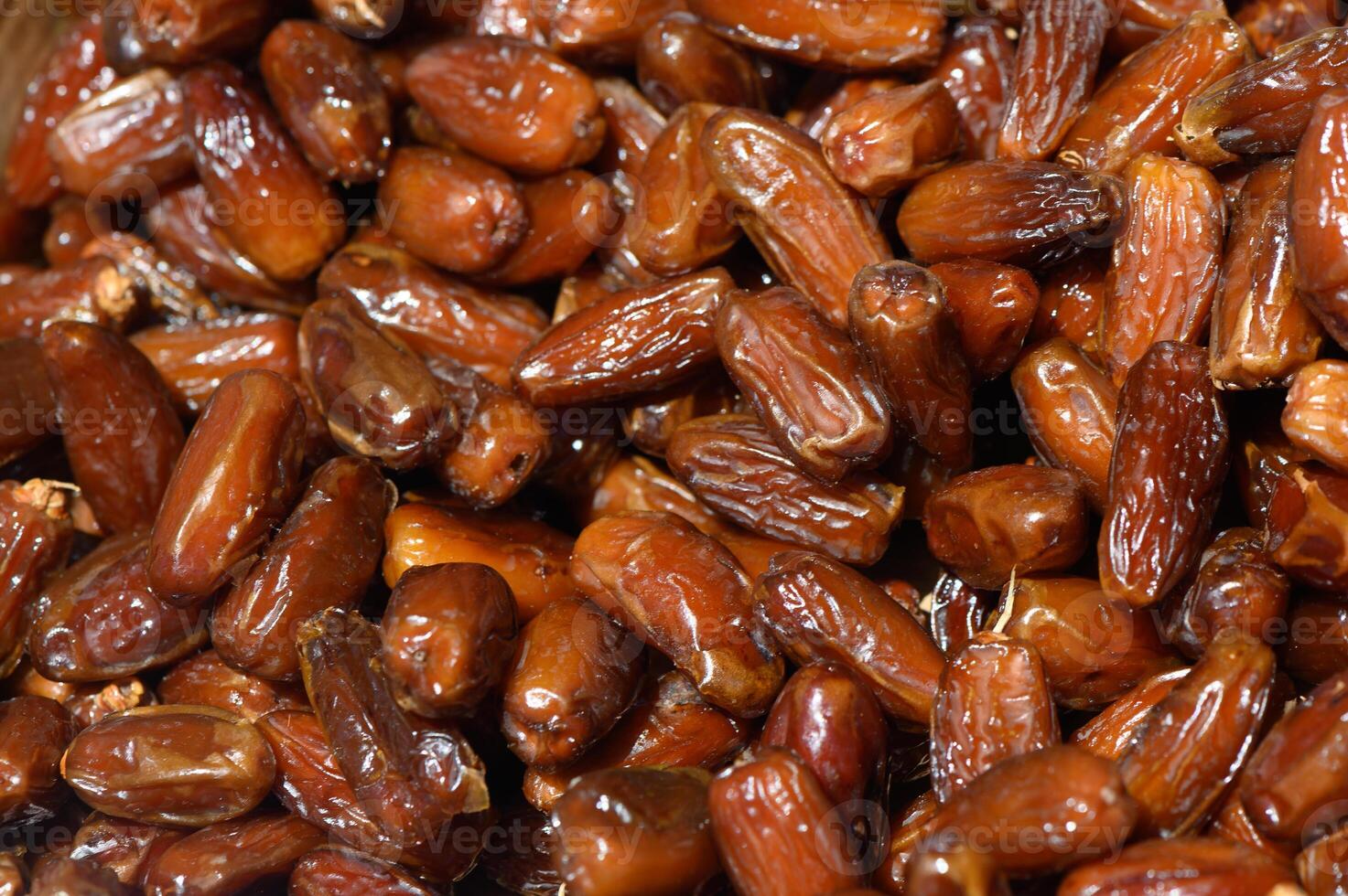 Freshly harvested dates beautifully arranged in a wooden bowl at a local market during the golden hour photo