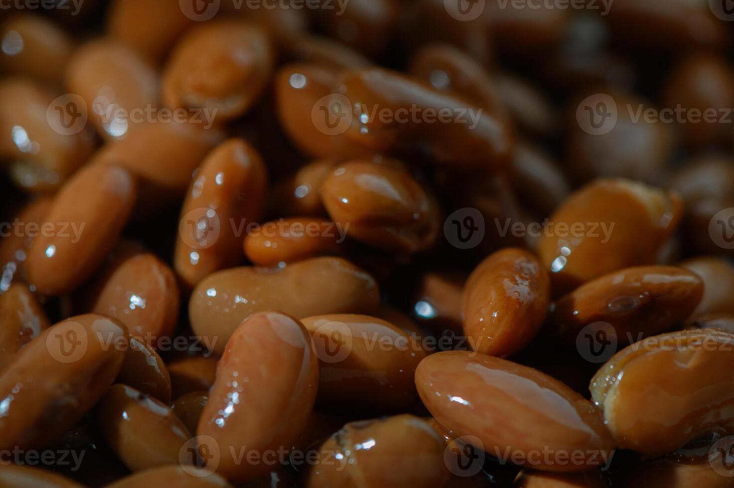 Rich brown kidney beans immersed in water, ready for cooking at a sunny kitchen table photo