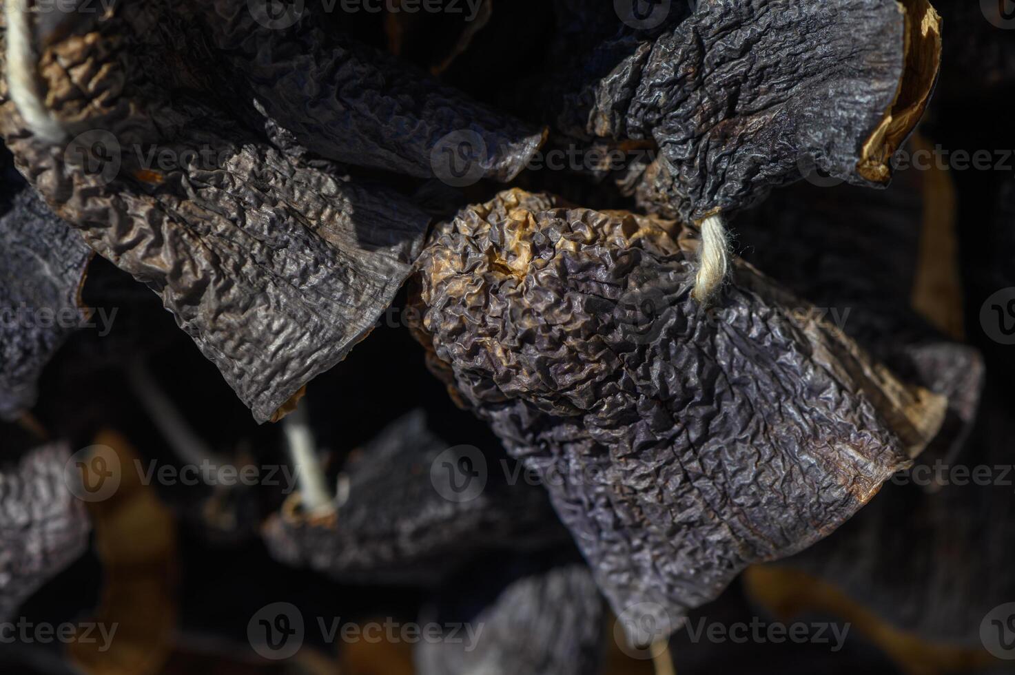 Dried petals resting in the sunlight create intricate shadows on a rustic wooden surface photo