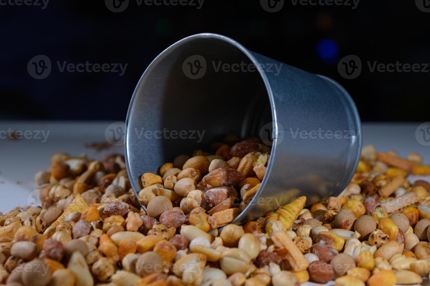 Colorful assortment of nuts and seeds spills from a tin container during a vibrant market day in autumn photo