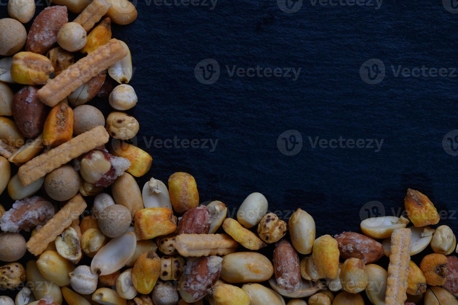 Colorful assortment of crunchy snacks arranged artistically on a dark surface creates an inviting atmosphere for casual gatherings photo
