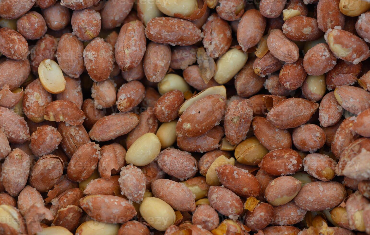 Natural blend of roasted peanuts showcasing various shades and textures in a vibrant arrangement photo