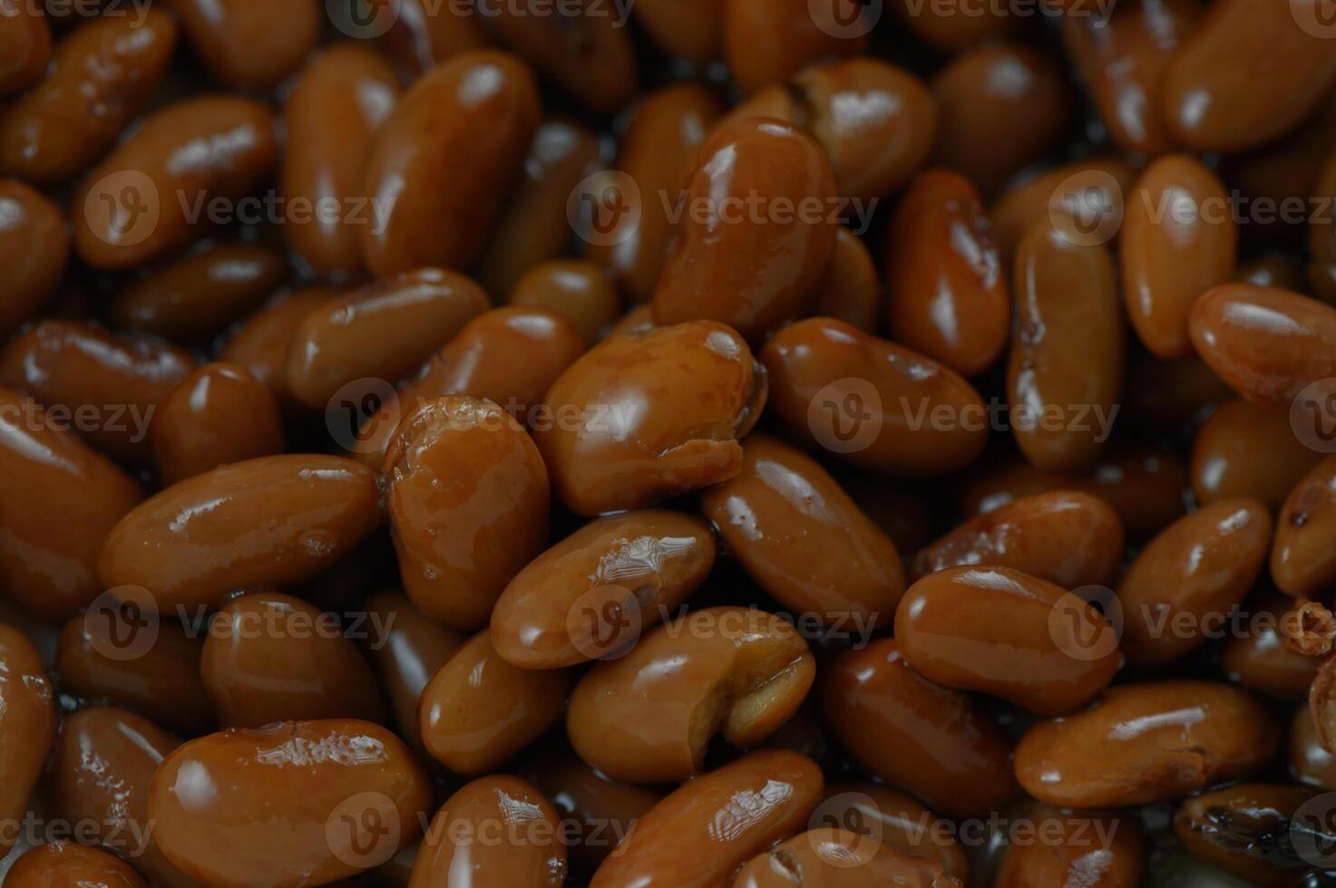 Rich and glossy brown beans nestled together, showcasing their natural sheen and earthy tones under soft lighting photo