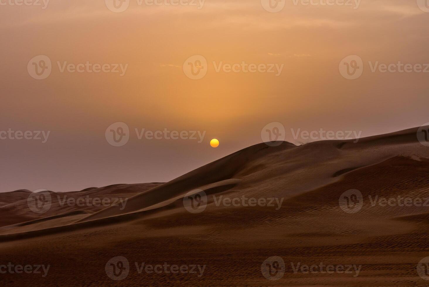A man is walking in the desert at sunset photo