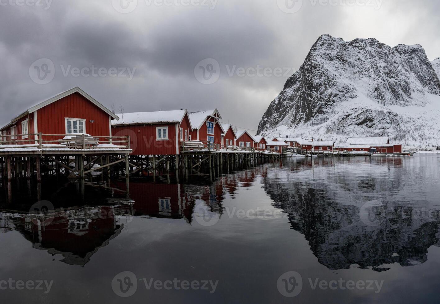 Red houses on the shore of a lake with mountains in the background photo