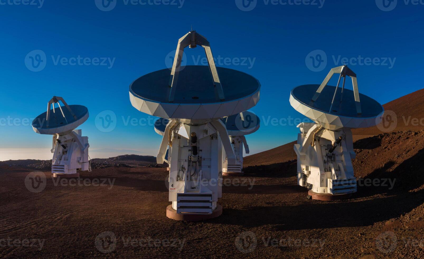 Four large telescopes sitting on top of a hill photo