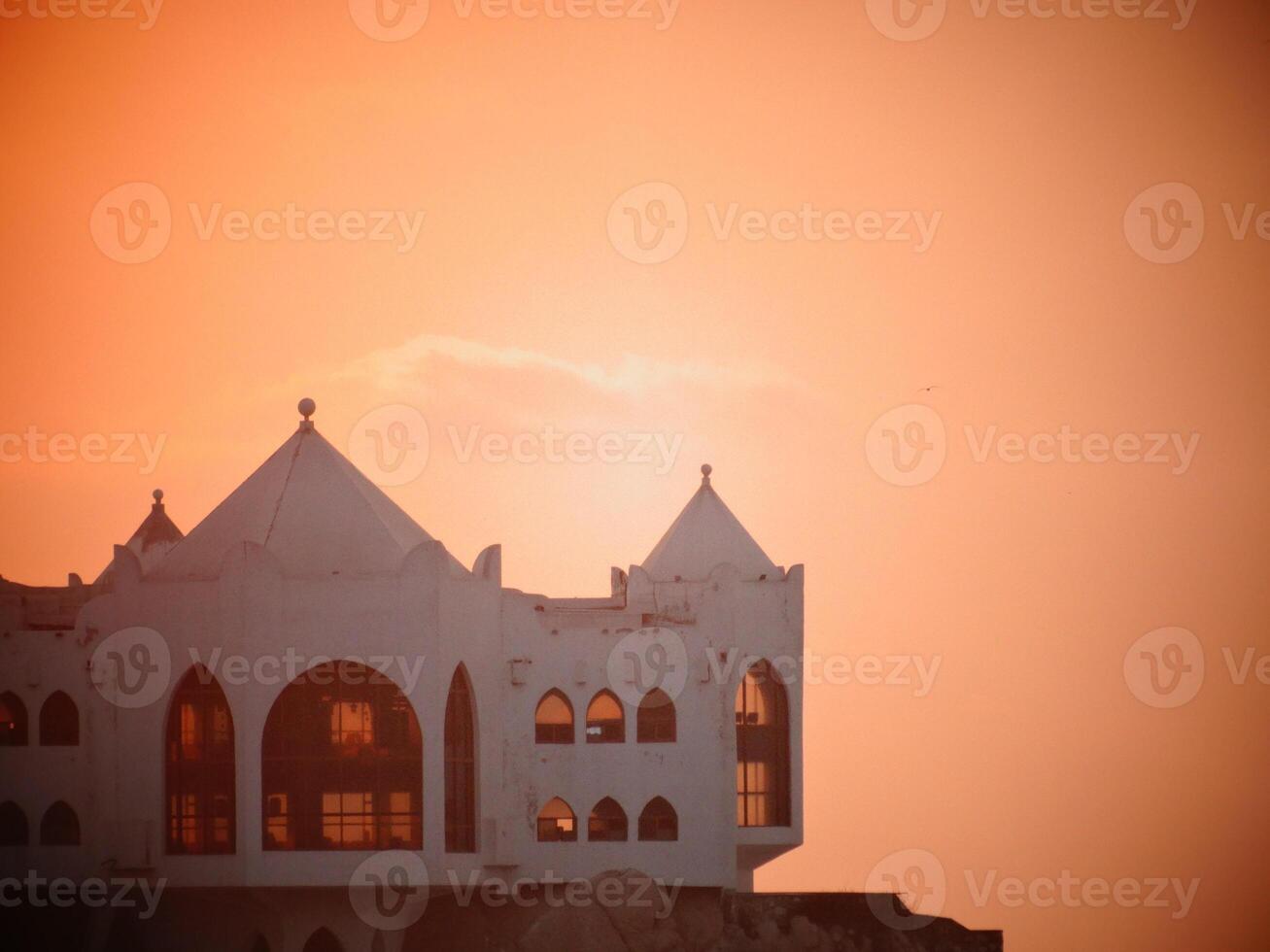 A large white building with a tower at sunset photo