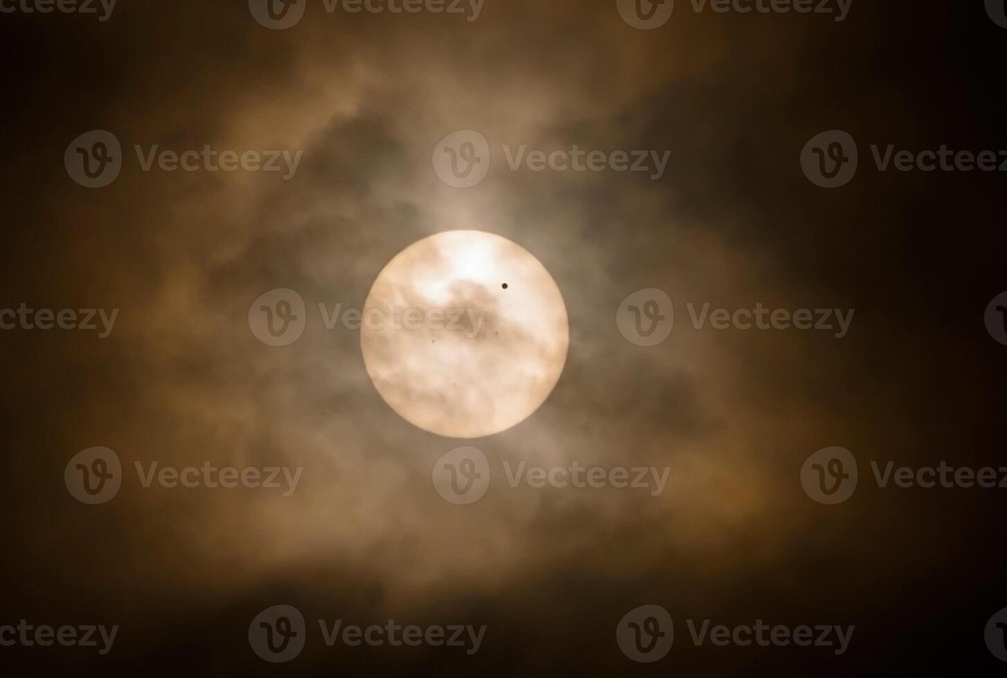 The sun is seen through a cloudy sky photo