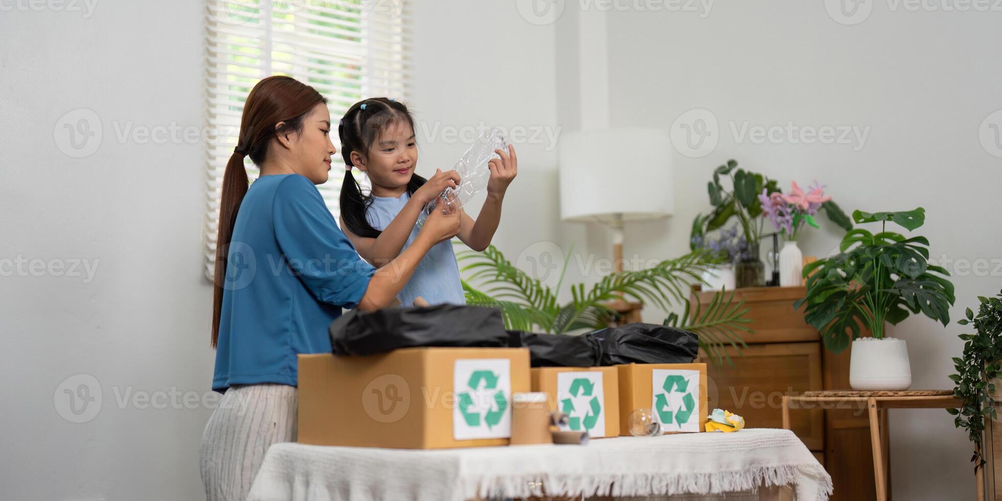 Learning Sustainability Together. A joyful mother and daughter sorting recyclable items at home, nurturing eco-consciousness. photo