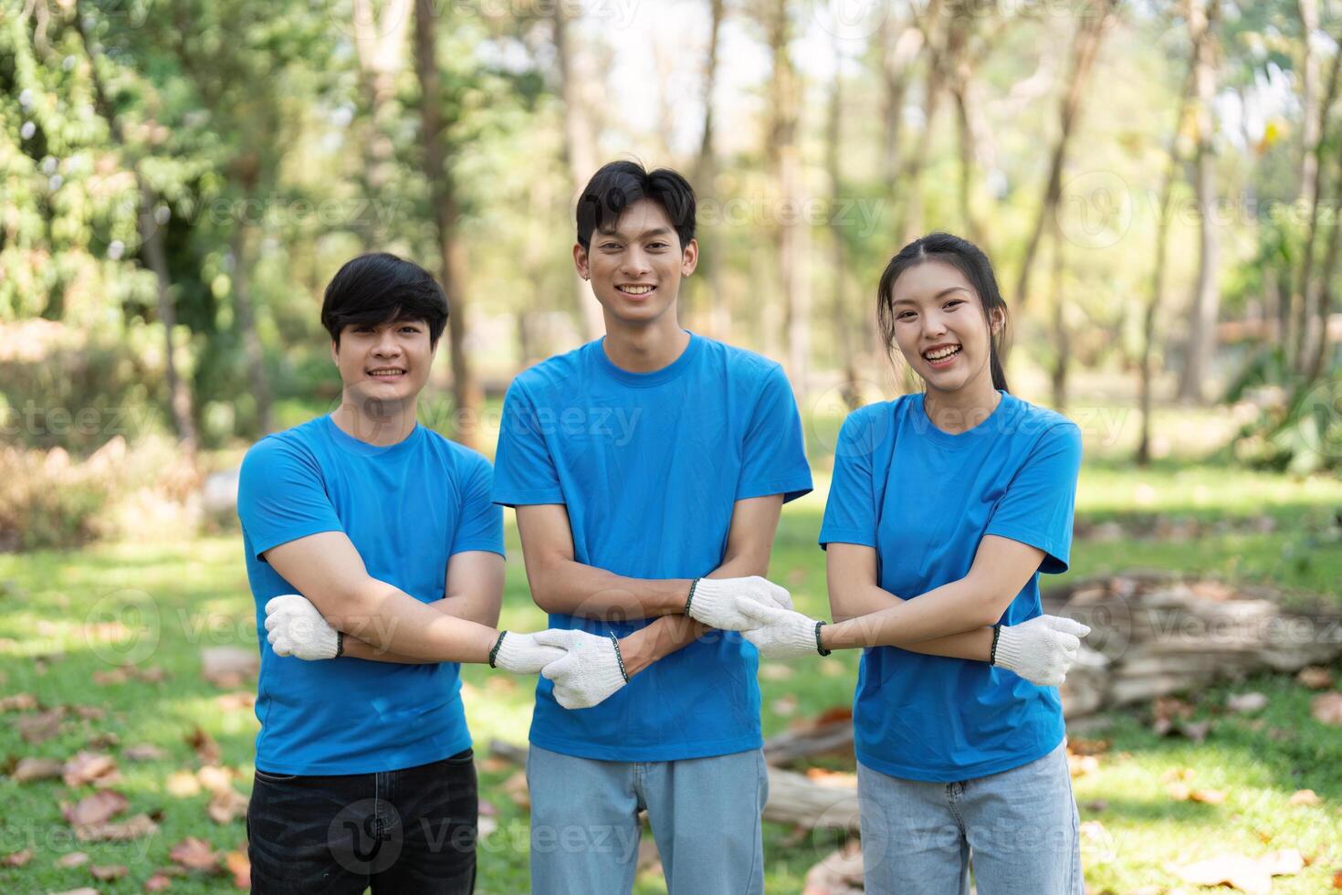 Community and Collaboration. Three smiling volunteers posing together after a successful park cleanup, fostering relationships through environmental action. photo
