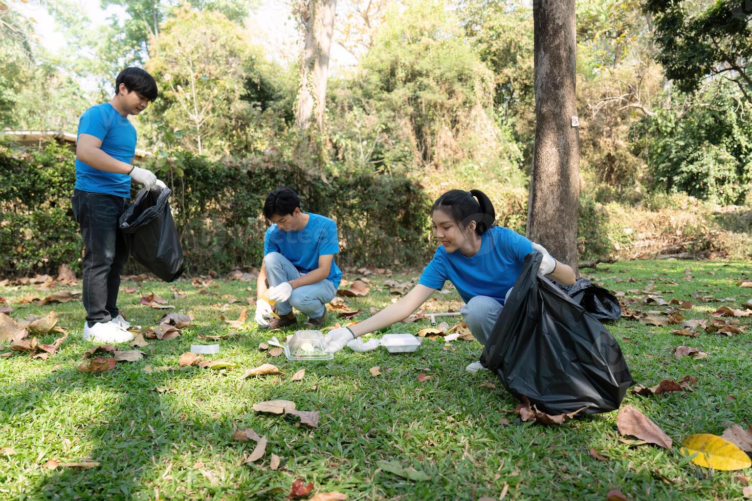 Environmental Awareness and Teamwork. Volunteers actively collecting trash while working together to beautify their local park space. photo