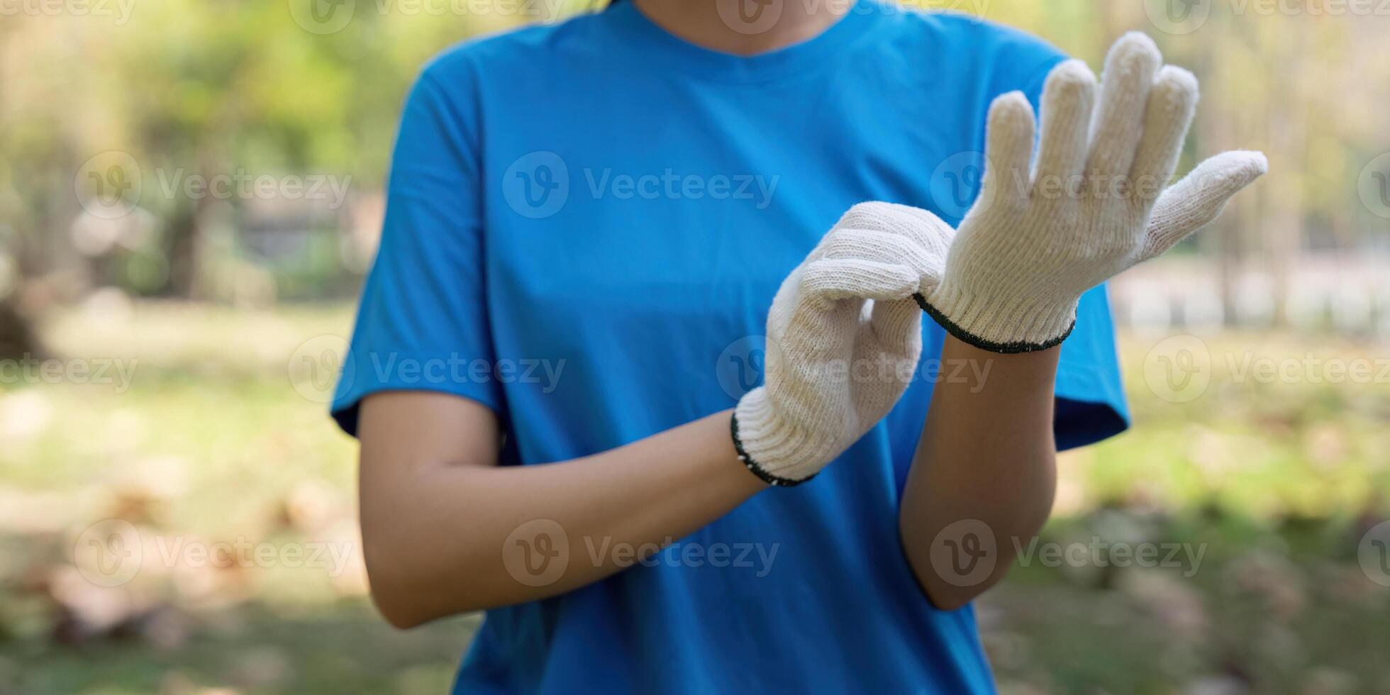 Volunteer Preparation and Environmental Health. A volunteer readies herself by putting on gloves, preparing for an outdoor cleanup. photo