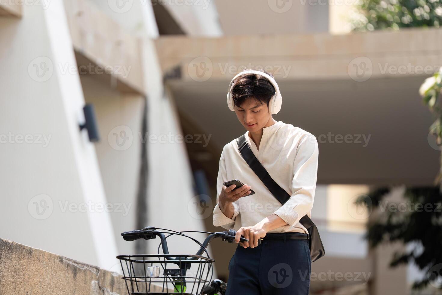 Modern Commuting and Digital Connectivity. A young man checks his phone while parked on his bicycle, enjoying a moment of tech-savvy relaxation. photo