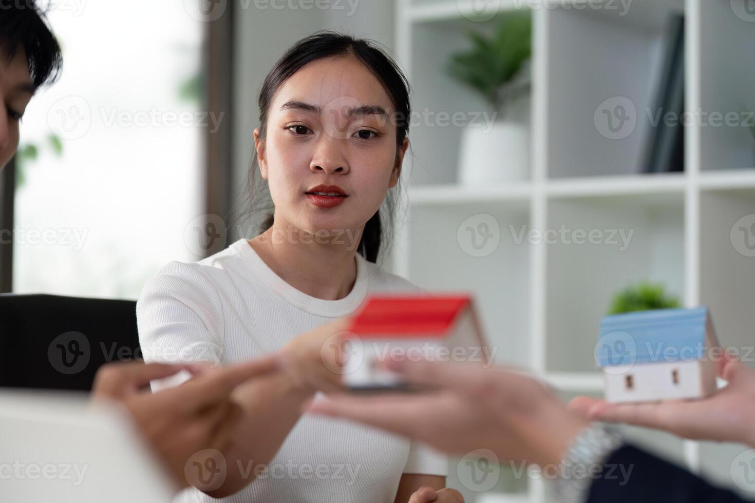 Real Estate Consultation and Decision-Making. A couple engages seriously with a real estate agent, discussing housing options. photo