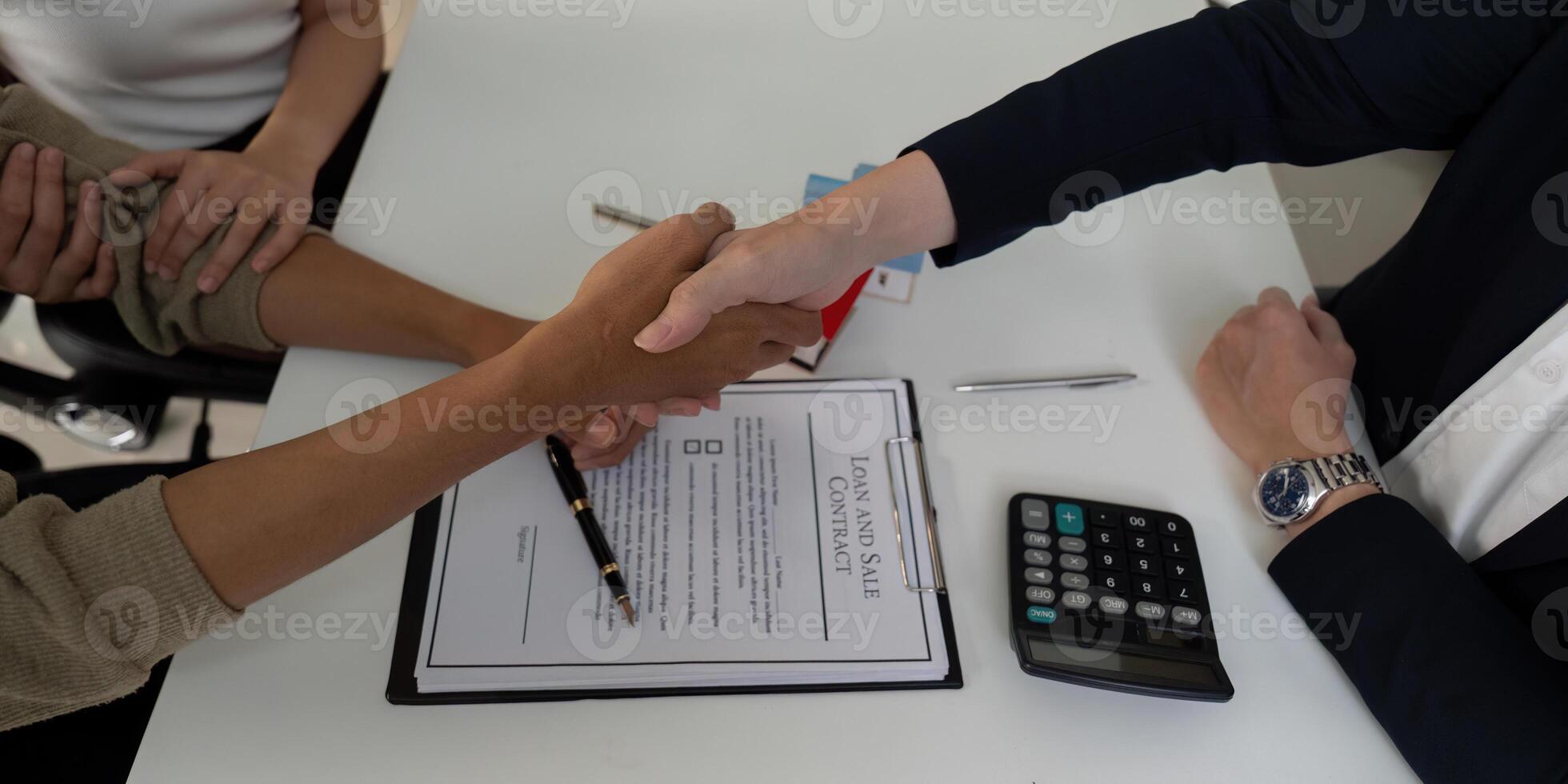 Agreement and Collaboration. A couple shakes hands with their real estate agent to finalize a sale. photo
