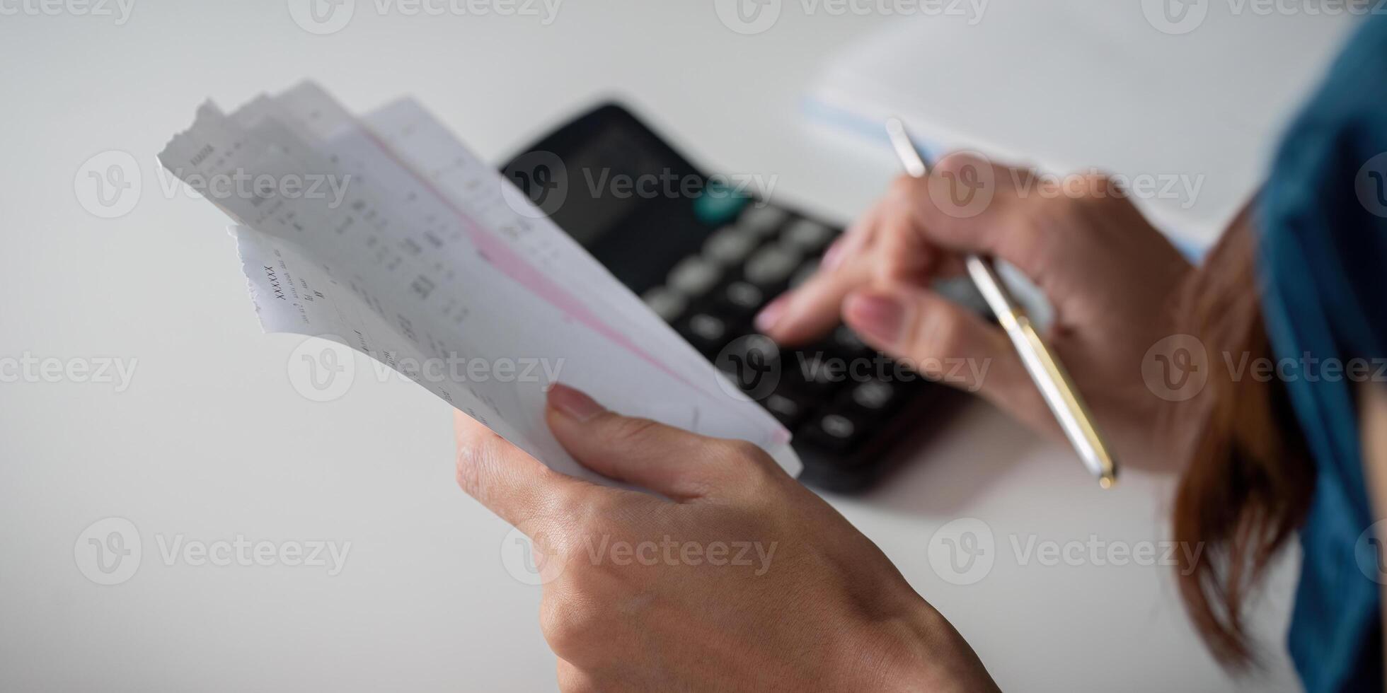 Expense Tracking and Calculating Savings. An individual reviewing receipts while calculating expenses with a calculator. photo
