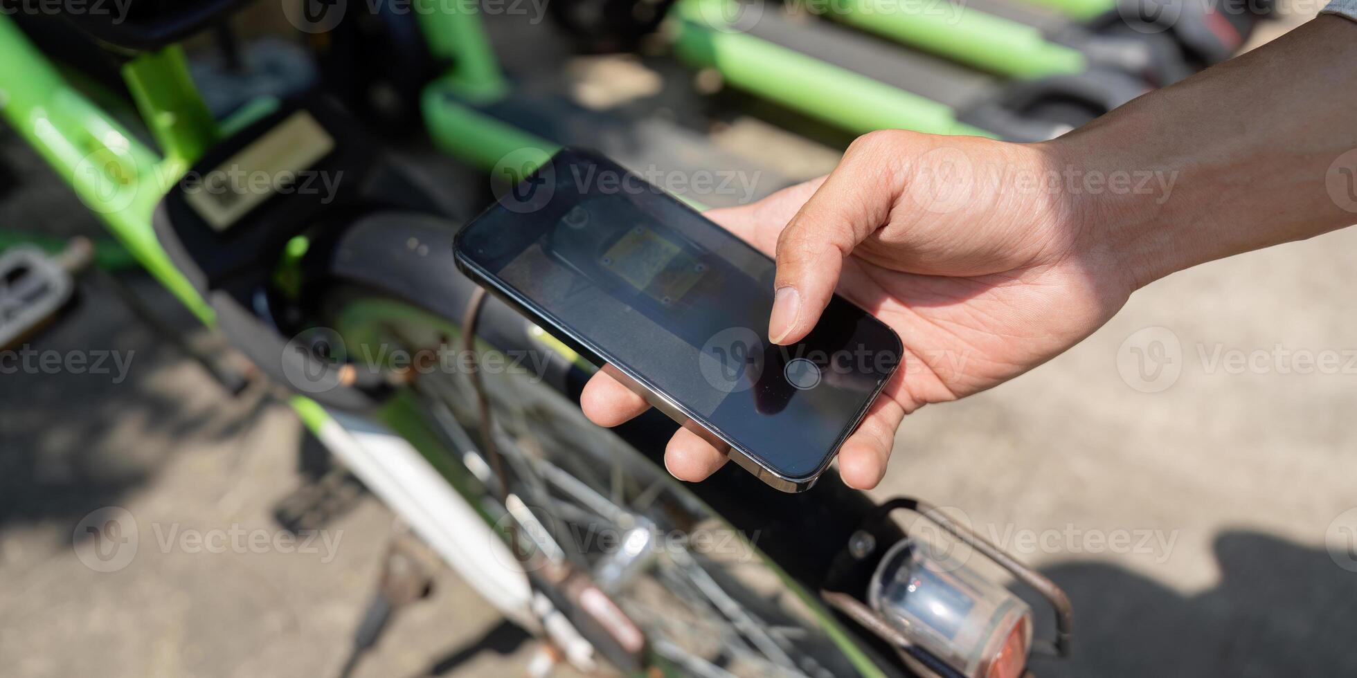 Smartphone Engagement and Bike Sharing. A close-up of a hand using a smartphone to interact with a bike-sharing service. photo