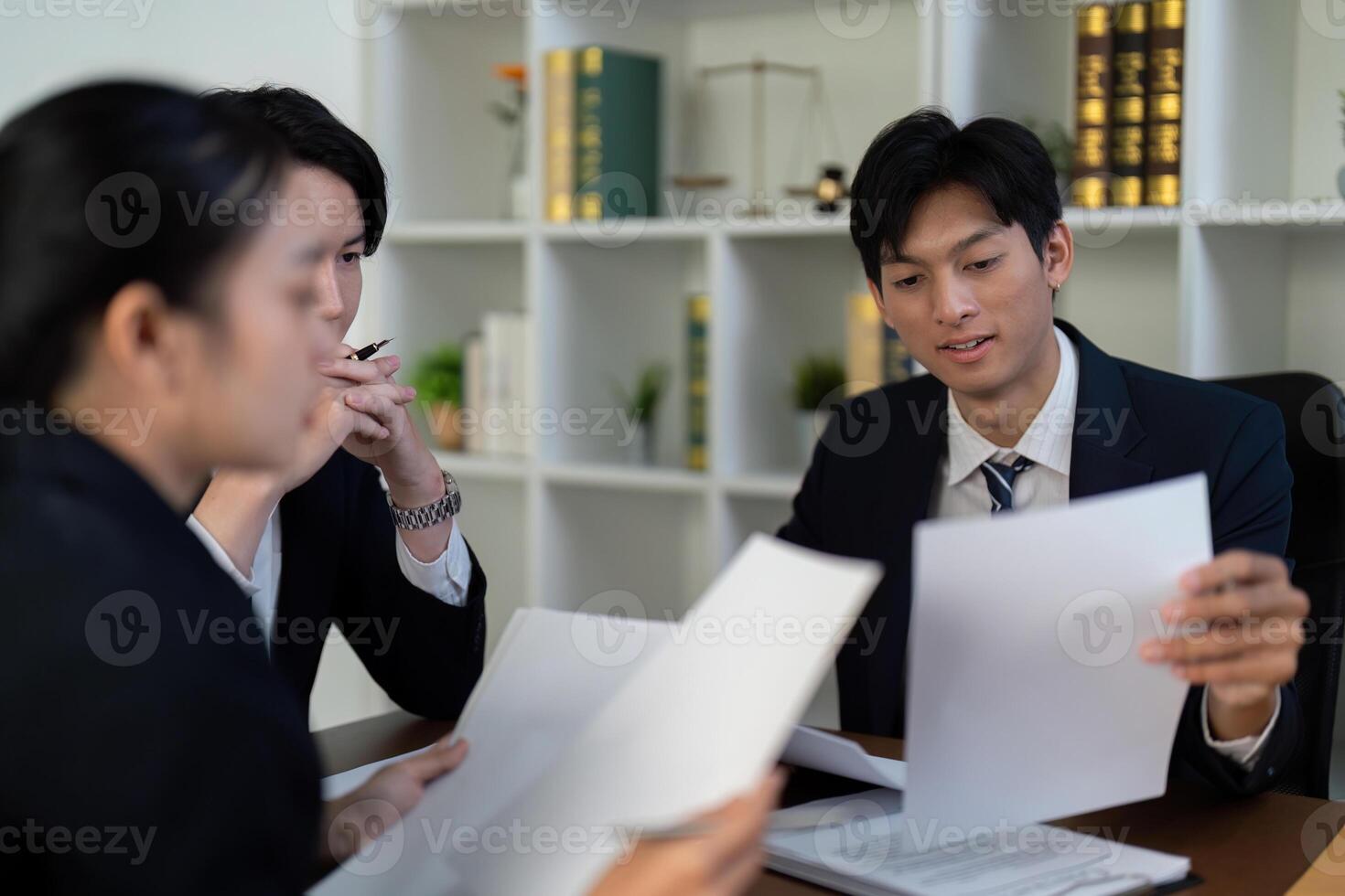 Documentation and Legal Insight. Lawyers reviewing important case files together. photo