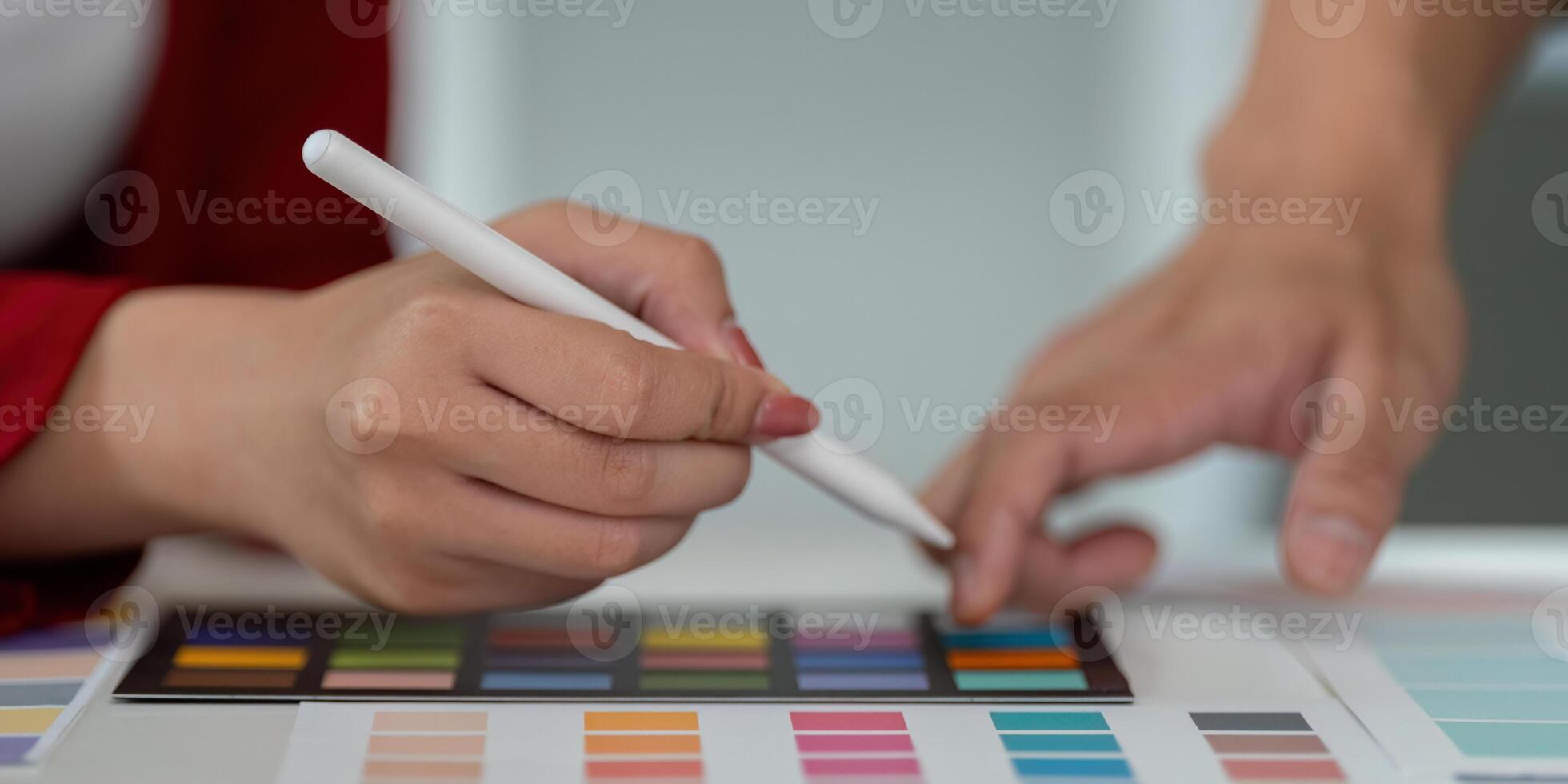 Creative Process and Hands-on Collaboration. Team members use tablets and color spreads to refine design concepts. photo
