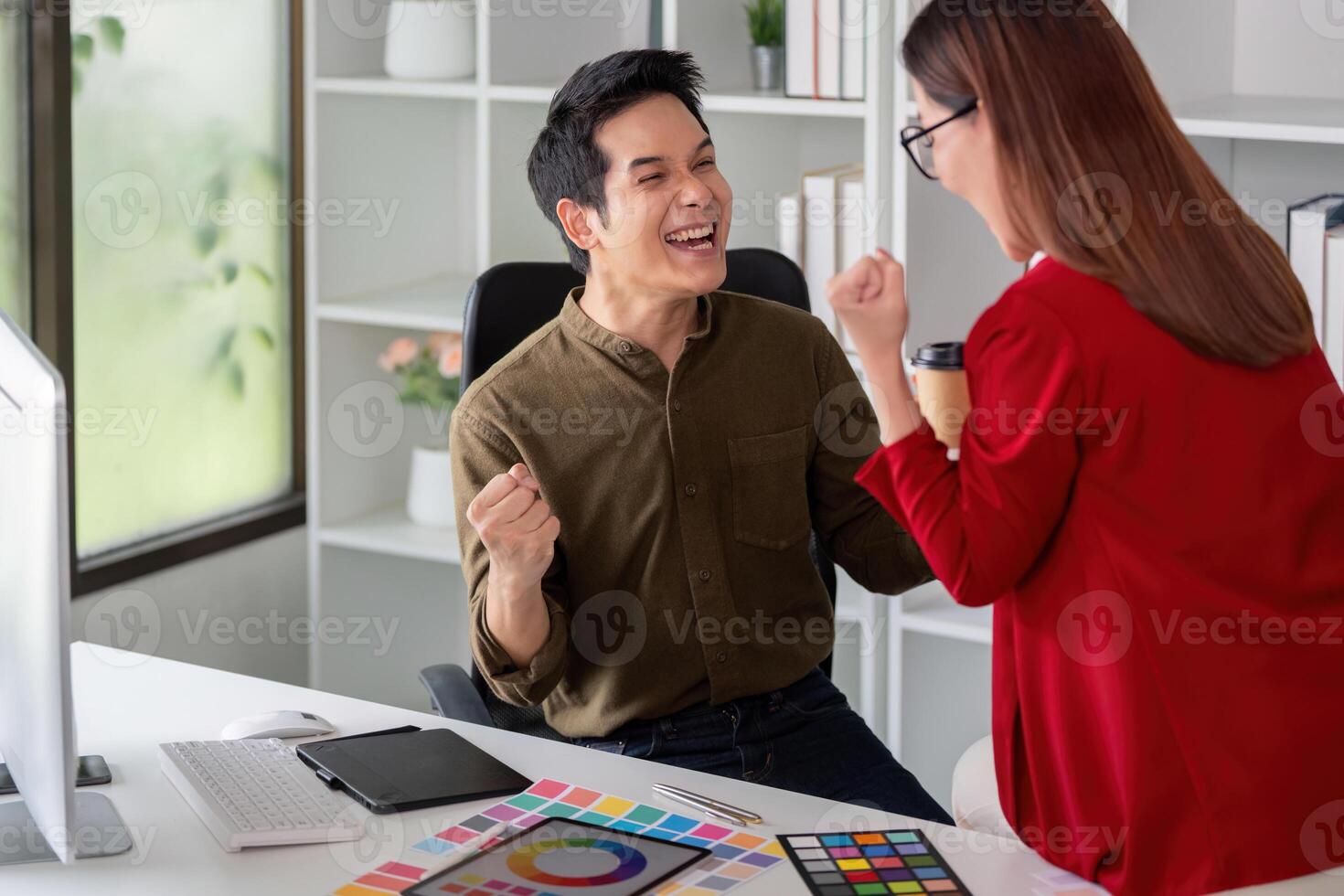 Creativity and Collaboration. A graphic designer and colleague celebrate their brainstorming session in a bright workspace. photo