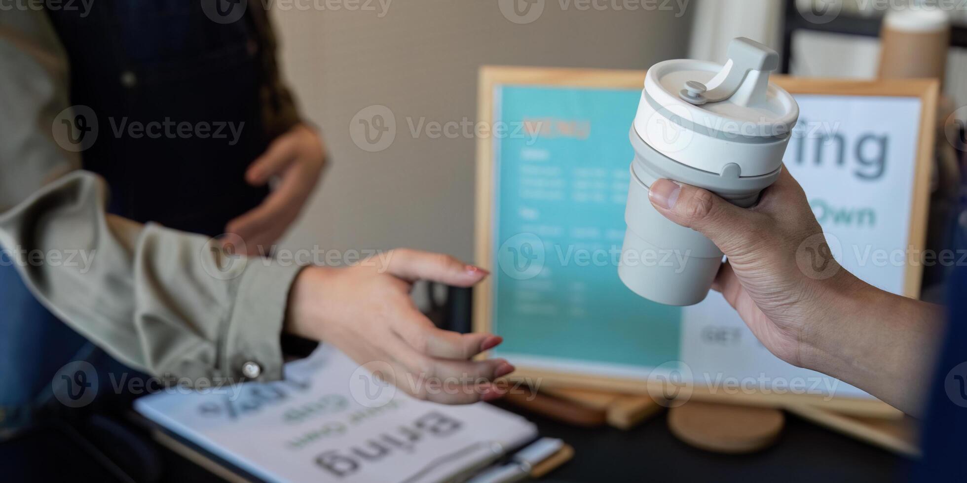 Promoting Sustainability and Eco-Consciousness. A cafe worker encourages customers to embrace reuse with their own cups. photo