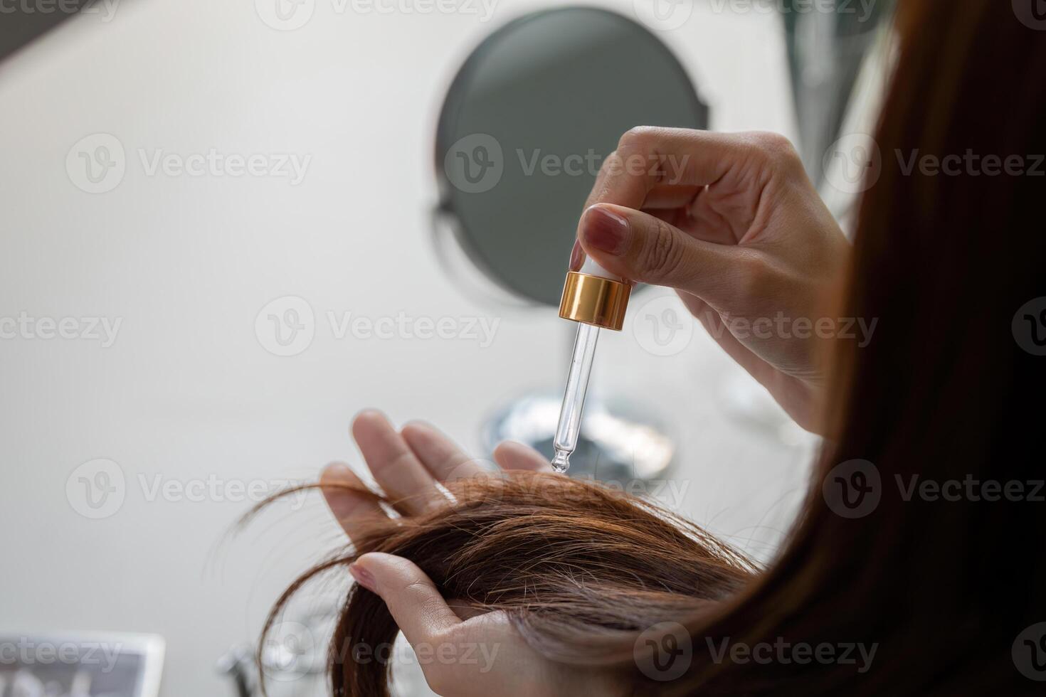 Hair Care and Beauty Routine. Applying hair serum for healthy and radiant locks. photo