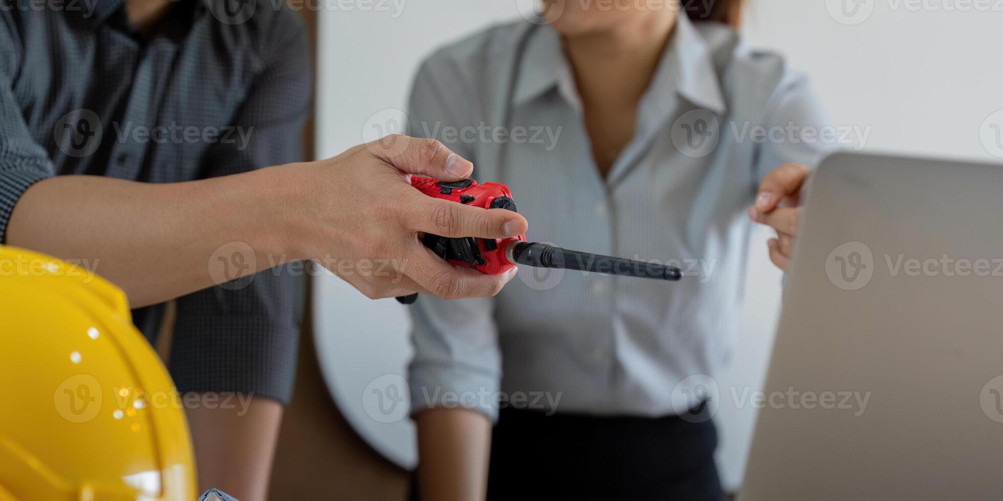 Communication and Coordination in Engineering. An engineer hands over a tool, fostering teamwork and connection in project execution. photo