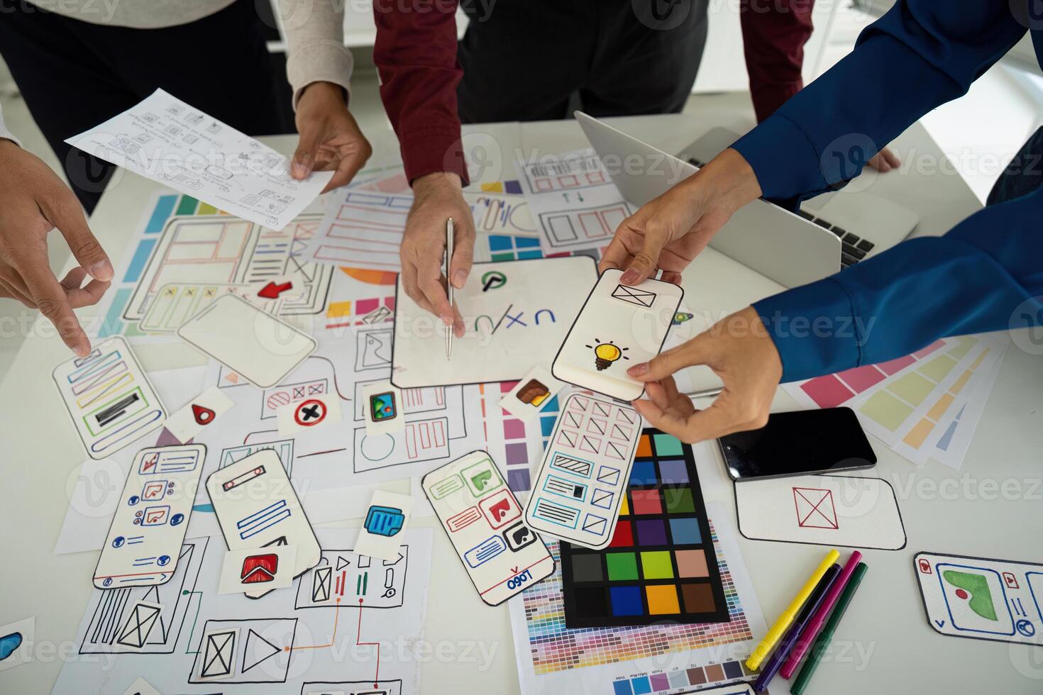 Design Process and Creative Input. Team examining design elements together to enhance digital user experience. photo