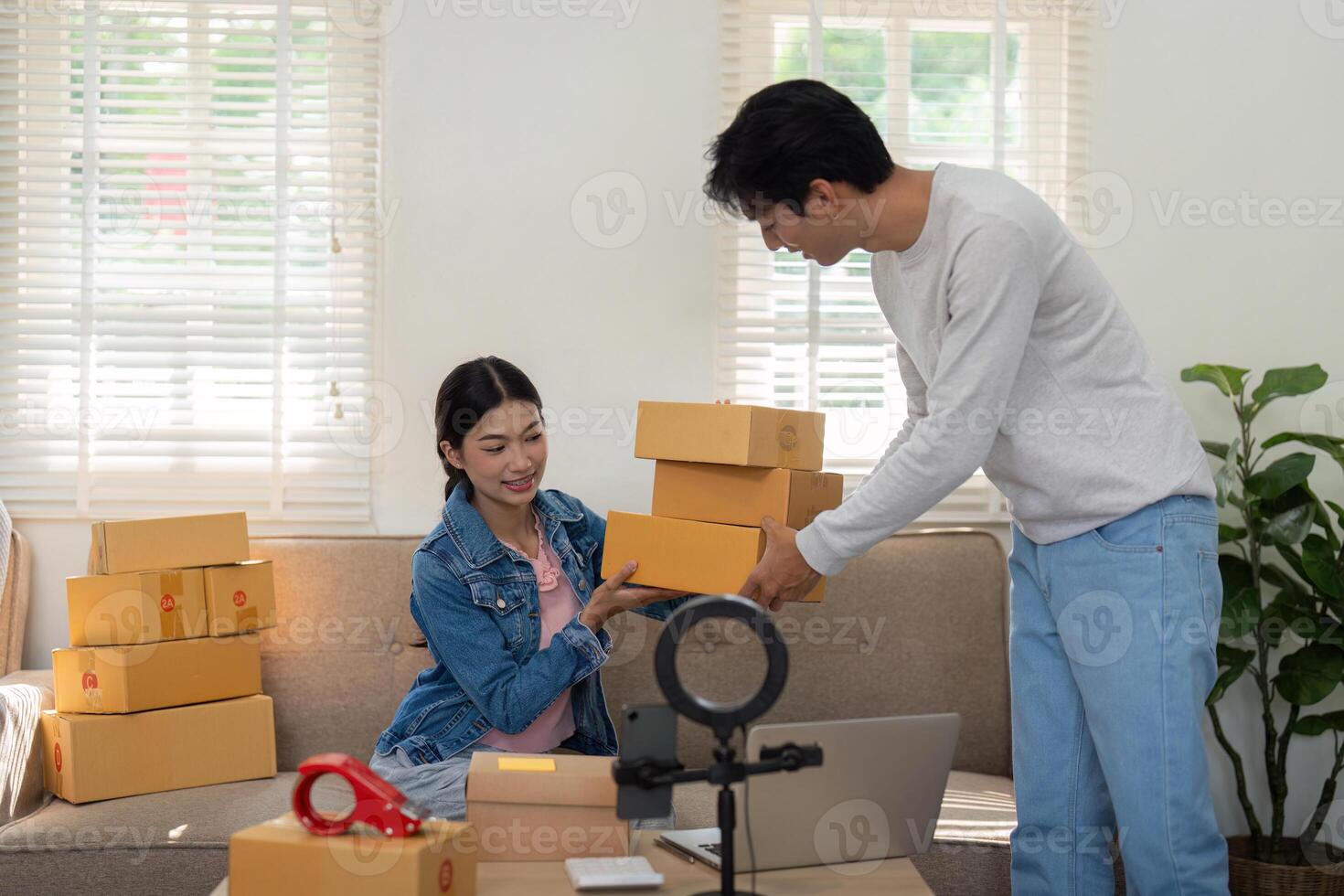 Entrepreneurship and Collaboration. A young woman and man are unboxing and preparing packages together for their new business venture. photo