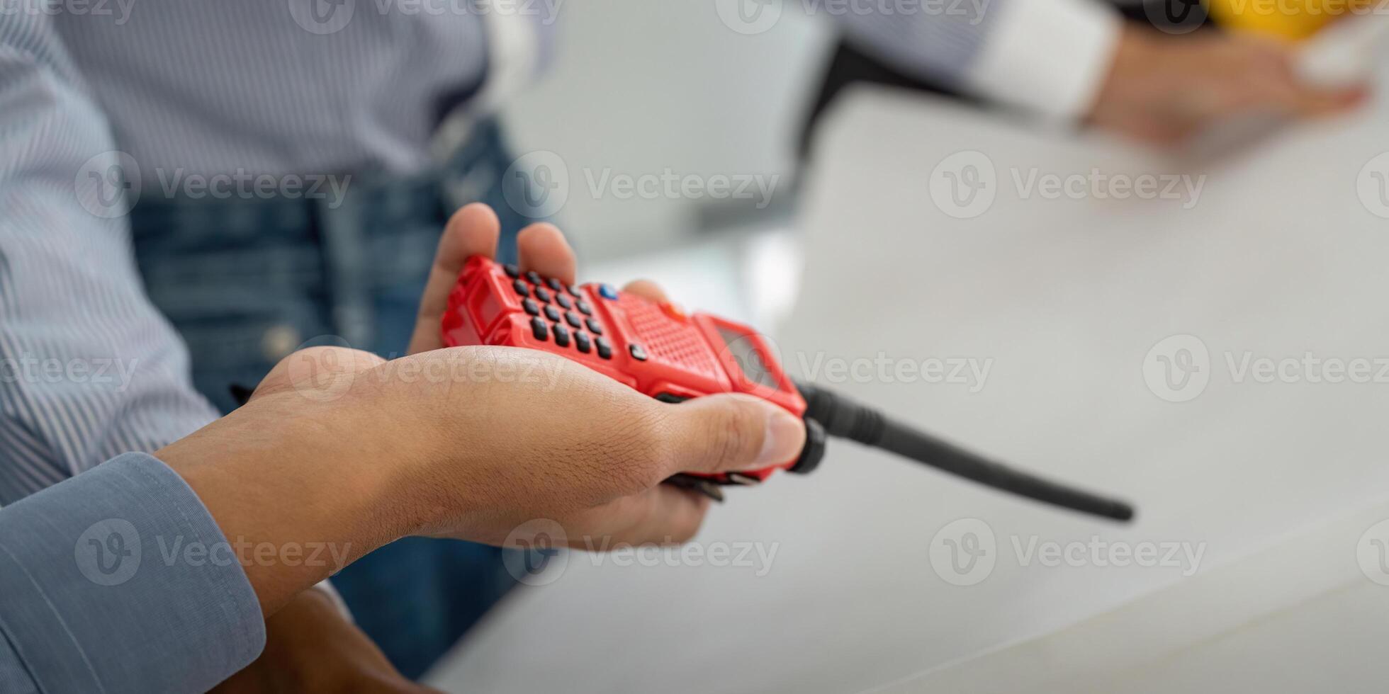 Communication and Collaboration. A professional holding a two-way radio to facilitate communication among team members. photo