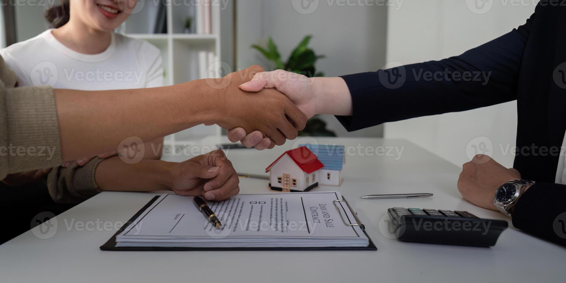 Closure and Business Agreement. A couple shakes hands with their real estate agent after concluding the sale. photo
