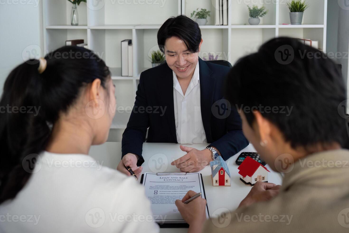 Client Consultation and Property Review. A couple focused on their real estate investment while discussing offers with their agent. photo