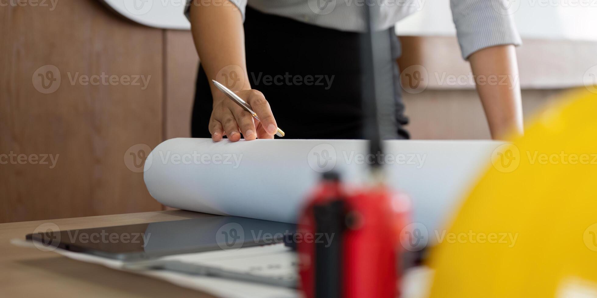 Architectural Planning and Collaboration. A hand holding a blueprint on a desk, indicating careful planning in a creative workspace. photo