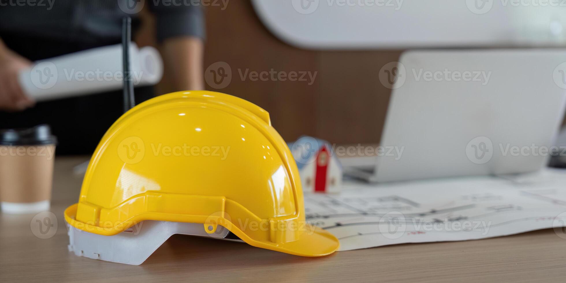 Safety and Planning. A yellow hard hat positioned on professional documents in an engineering workspace. photo