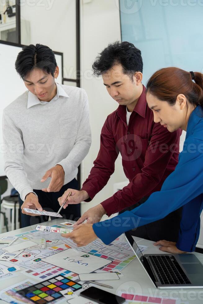 Collaborative Design Review and Strategy. Professionals assessing digital prototypes while discussing design strategy. photo