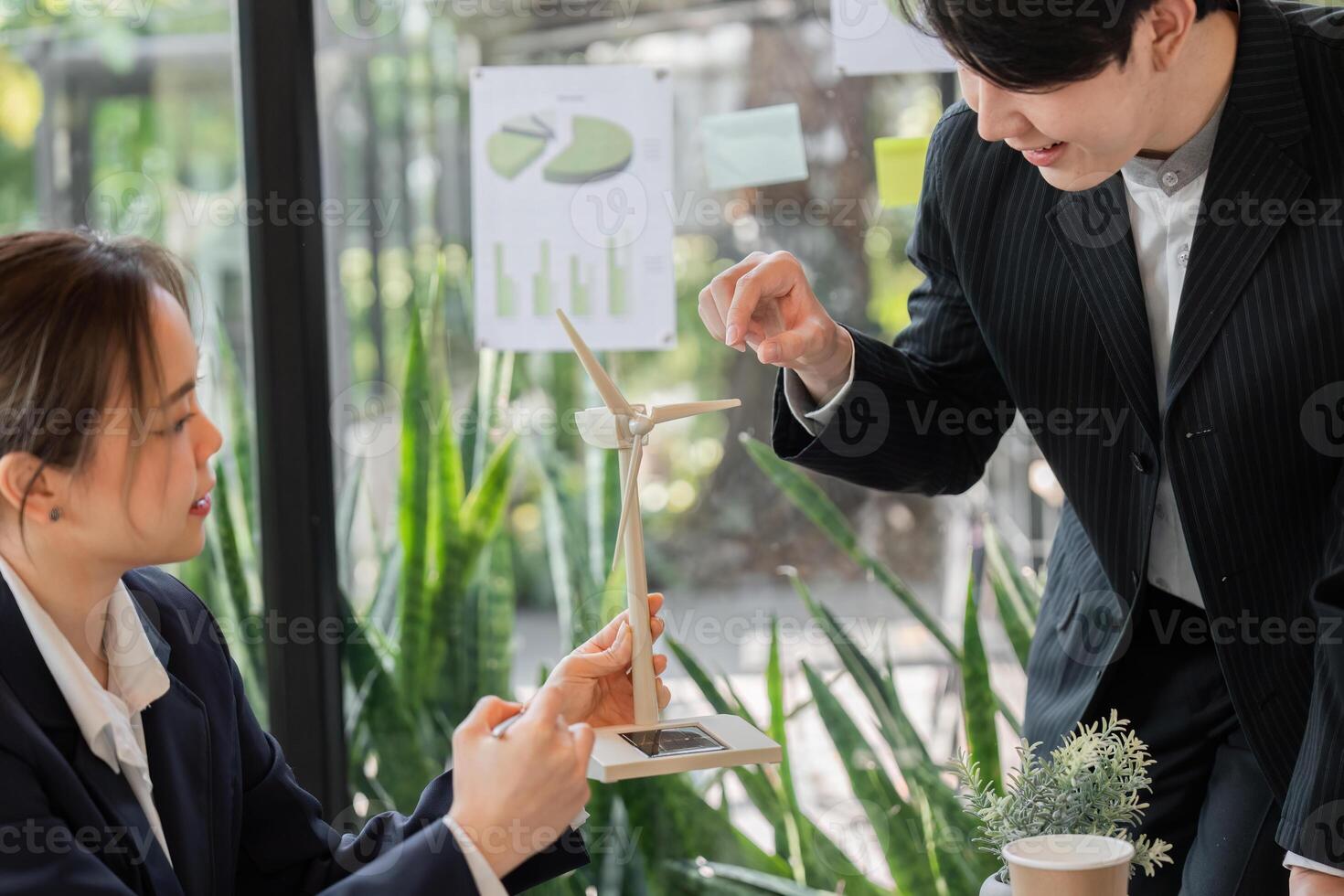 Sustainability and Renewable Energy. Professionals discussing a wind turbine model, exploring renewable energy solutions for a greener future. photo