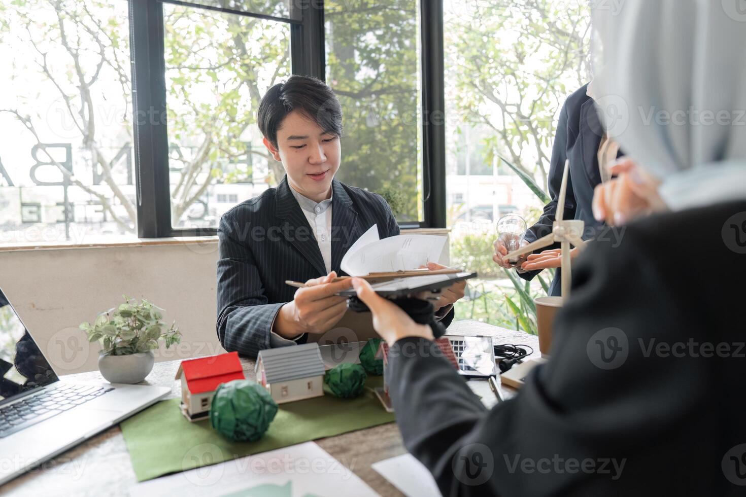 Sustainability and Collaboration. Presenting innovative eco-friendly housing designs in a collaborative meeting. photo