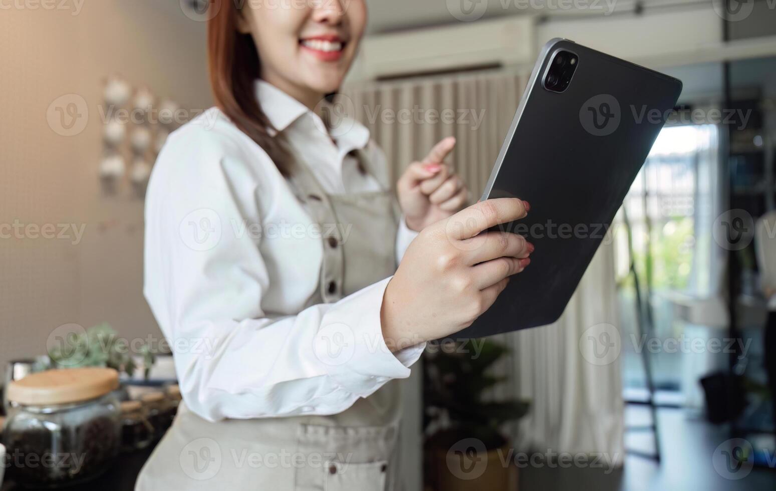 Digital Management in Coffee Shops. A barista interacts with a tablet, enhancing customer experience. photo