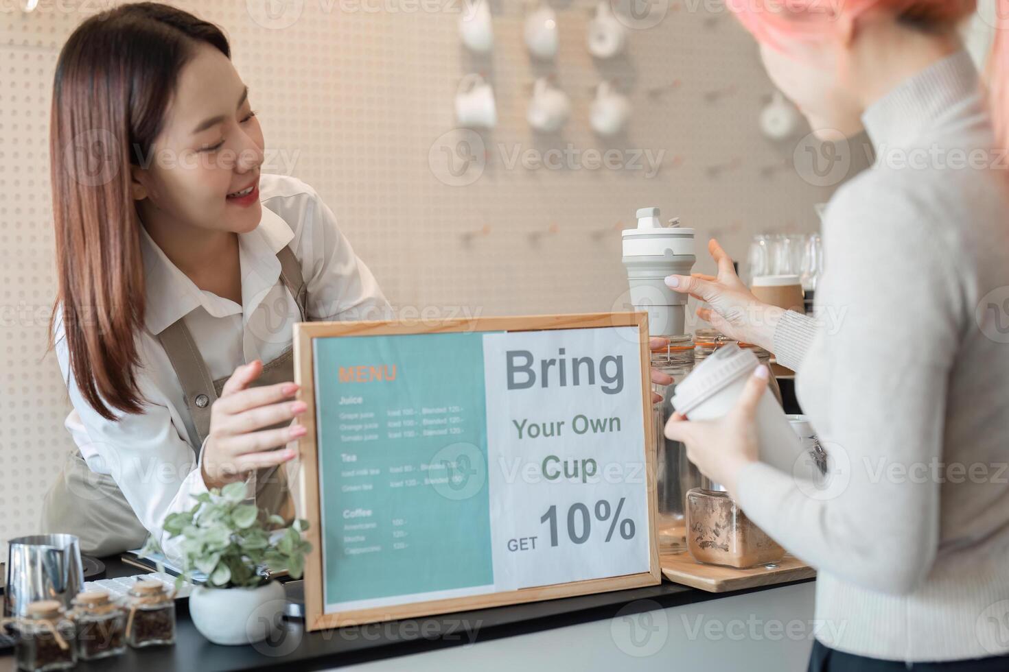 Sustainability and Coffee Culture. A barista encouraging customers to bring reusable cups for a discount. photo