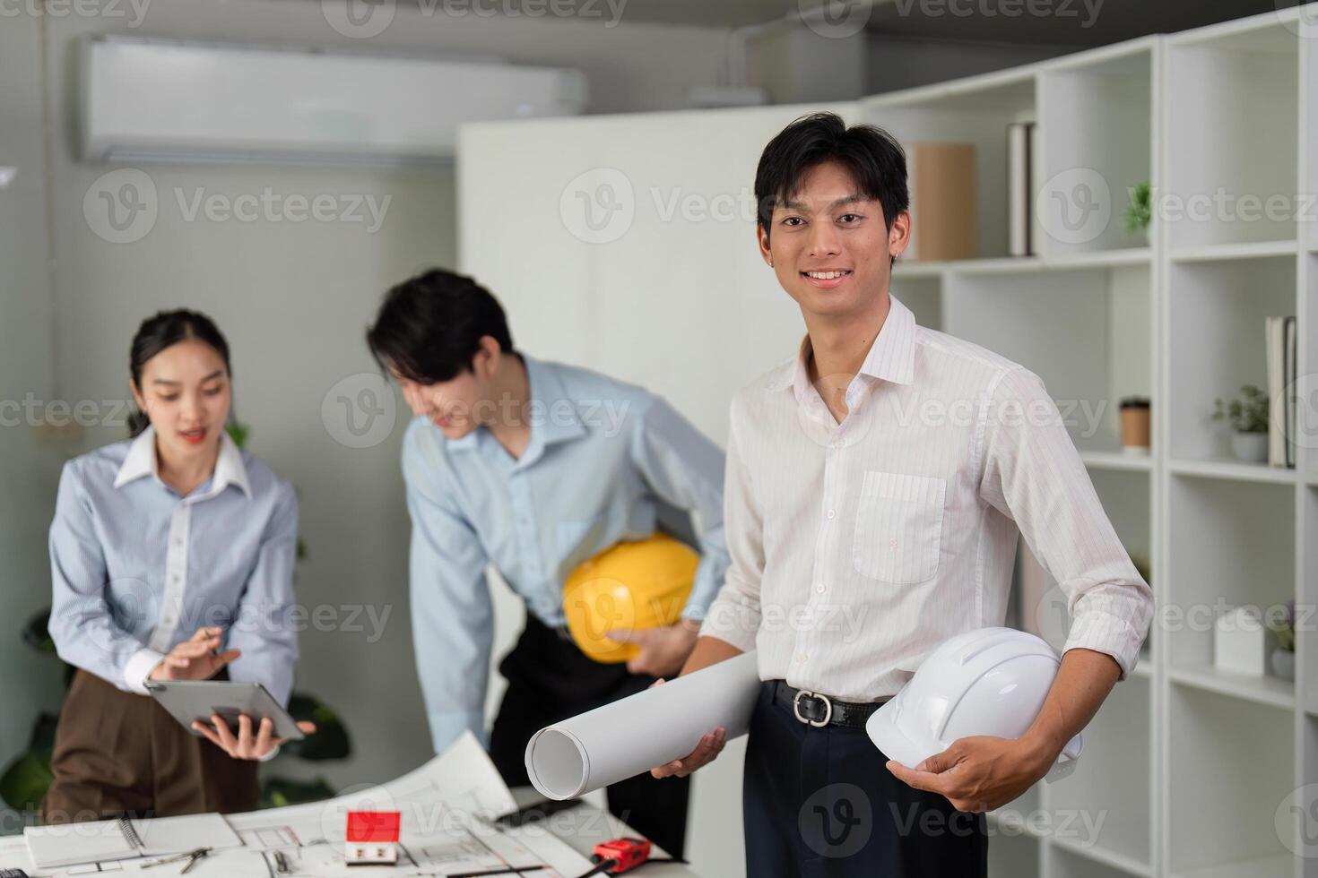 Project Coordination and Positive Vibes. A cheerful team plans their upcoming project using digital tools and construction helmets. photo