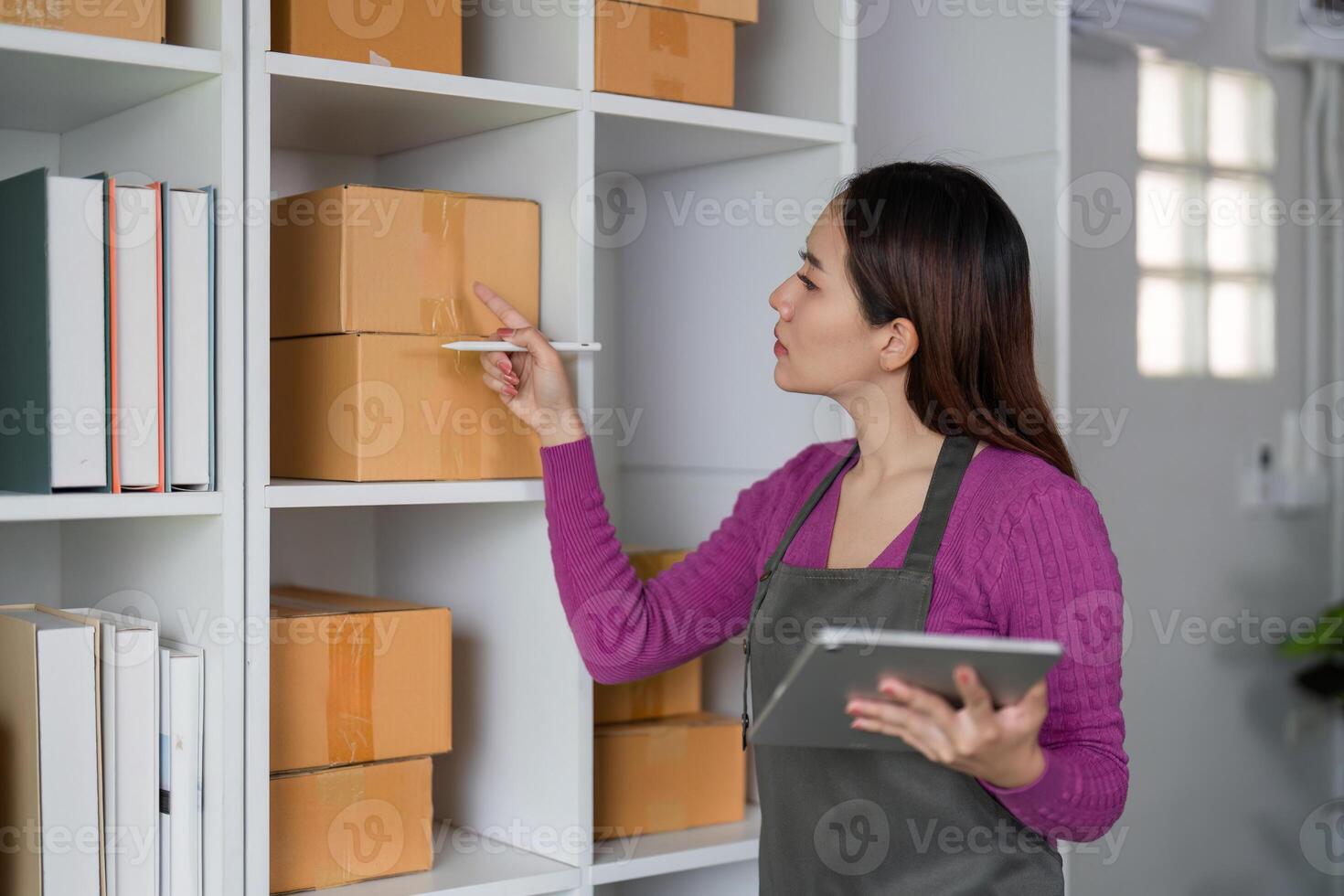 E-commerce and Stock Organization. A woman checking inventory levels while preparing for online sales in a tidy warehouse. photo