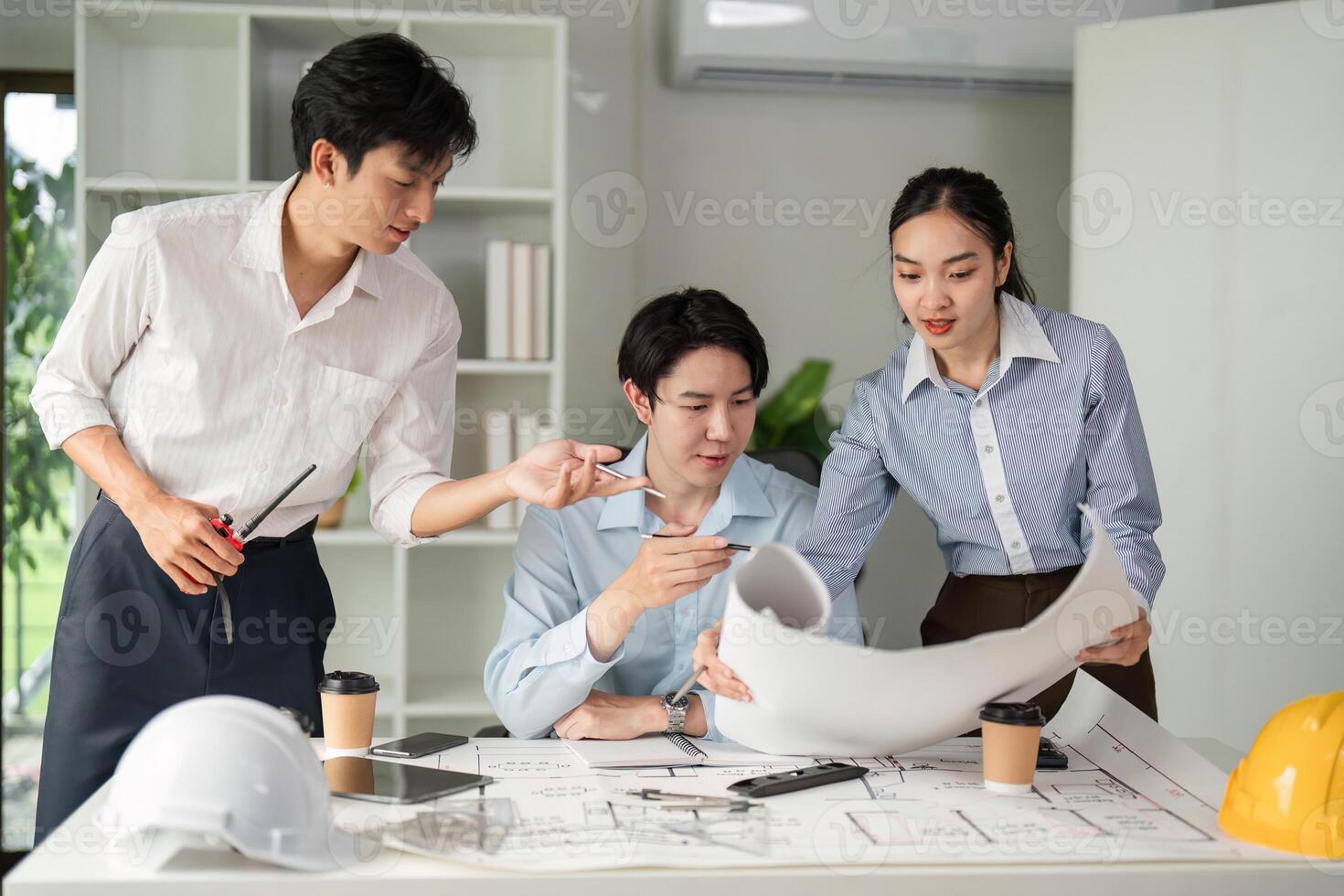 Collaboration and Project Planning. A creative team discussing blueprints and design strategies in a modern workspace. photo