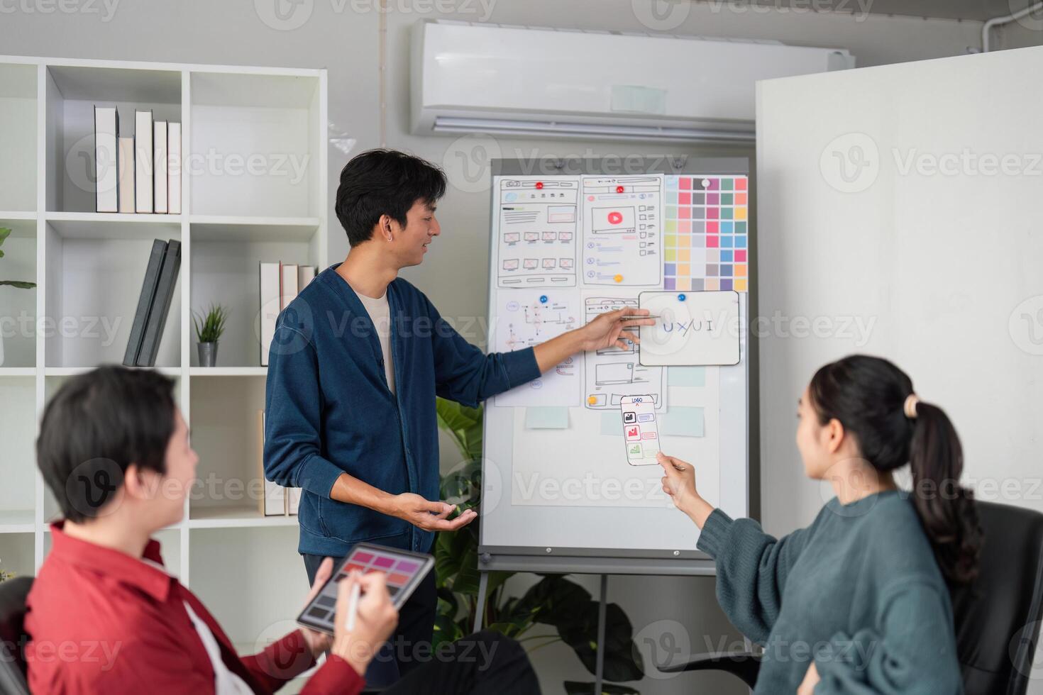 Collaborative Design Session. A team discusses a UI project while analyzing relevant wireframes. photo