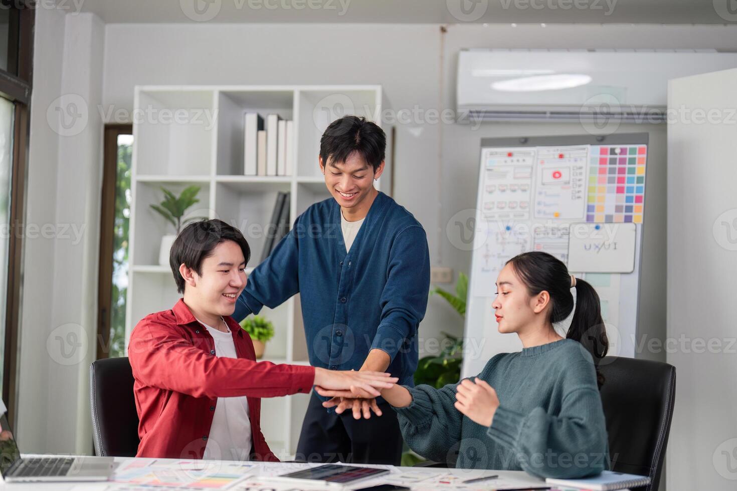 Creative Team Dynamics and Engagement. A group of young designers collaborating on ideas in a modern office environment. photo