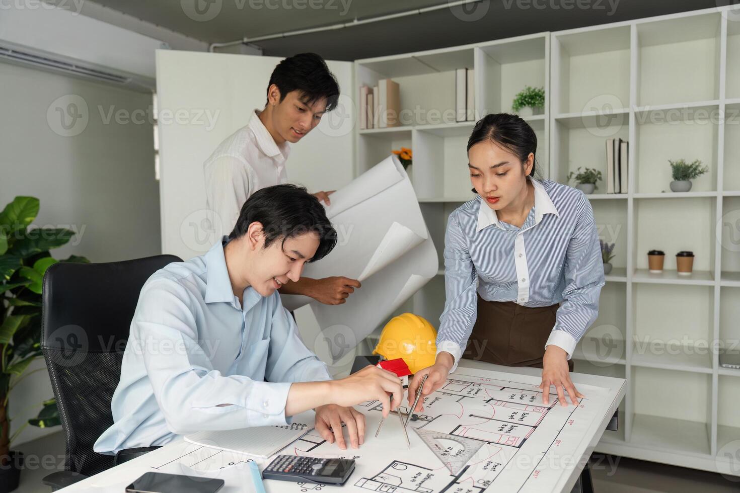 Collaboration and Planning. A team of architects working together on building designs, analyzing blueprints and discussing project details. photo
