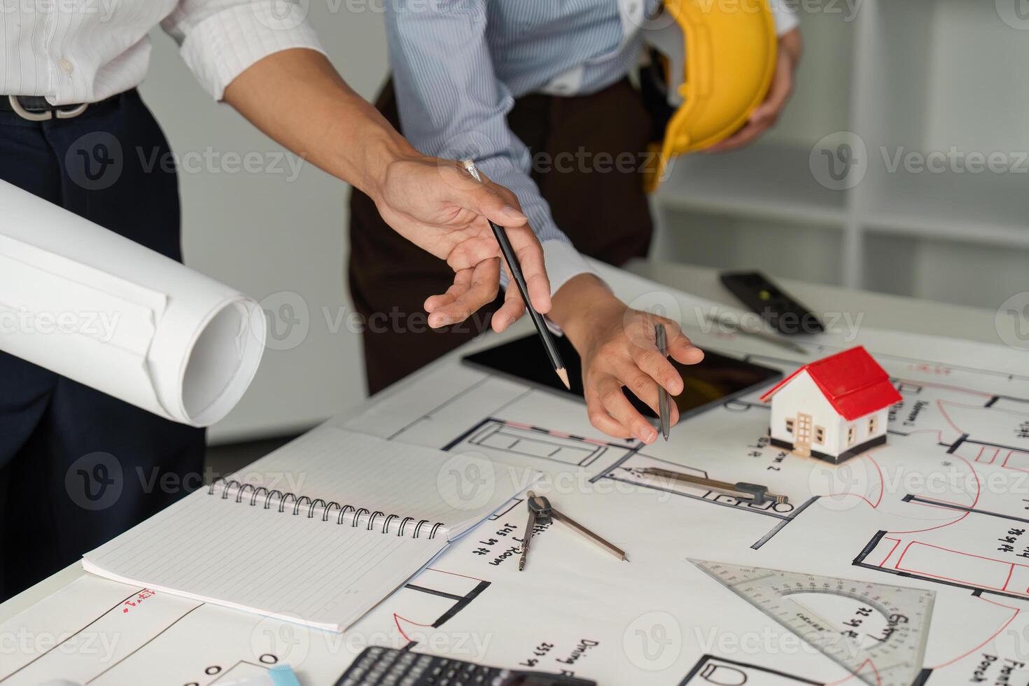 Design Development and Analysis. Professionals analyzing architectural blueprints and designs in an office setting. photo