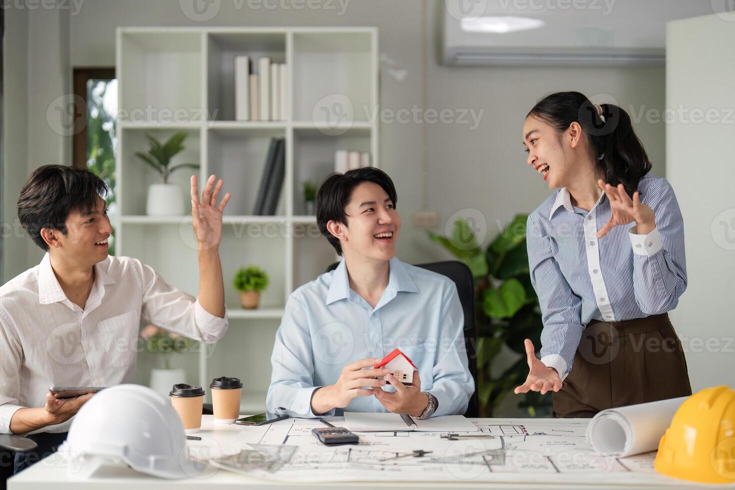 Collaboration and Creative Discussion. A vibrant team exchange ideas over architectural concepts and designs. photo