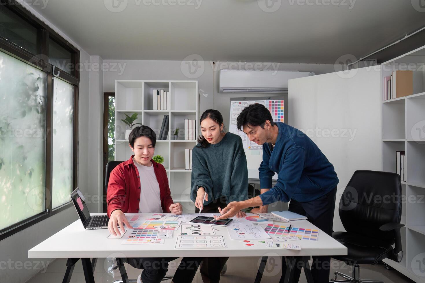 Teamwork and Design Process. Diverse designers collaborating on a UIUX project in a creative workspace. photo