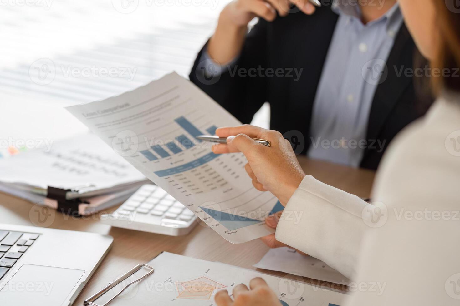 Business Meeting and Data Analysis. Professionals collaborating on financial reports during a meeting. photo